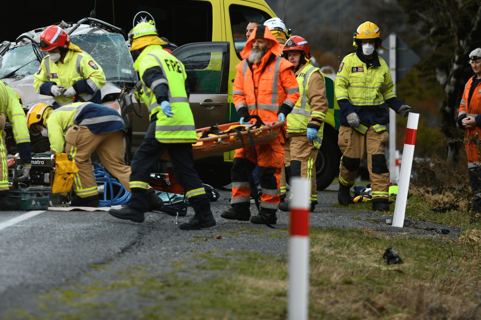Paramedics and firefighters treating a patient at a crash scene